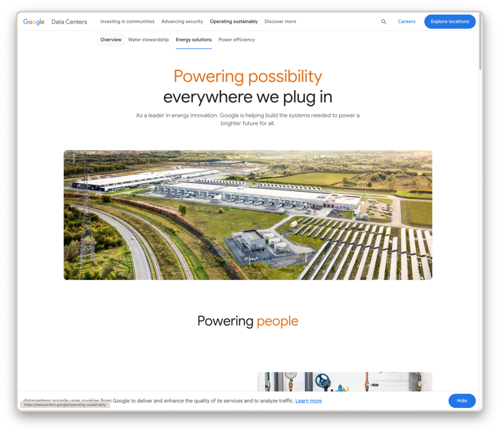 An image of a screenshot from the Google Data Center website showing a large data center facility along with gleaming solar panels to the right hand side. 